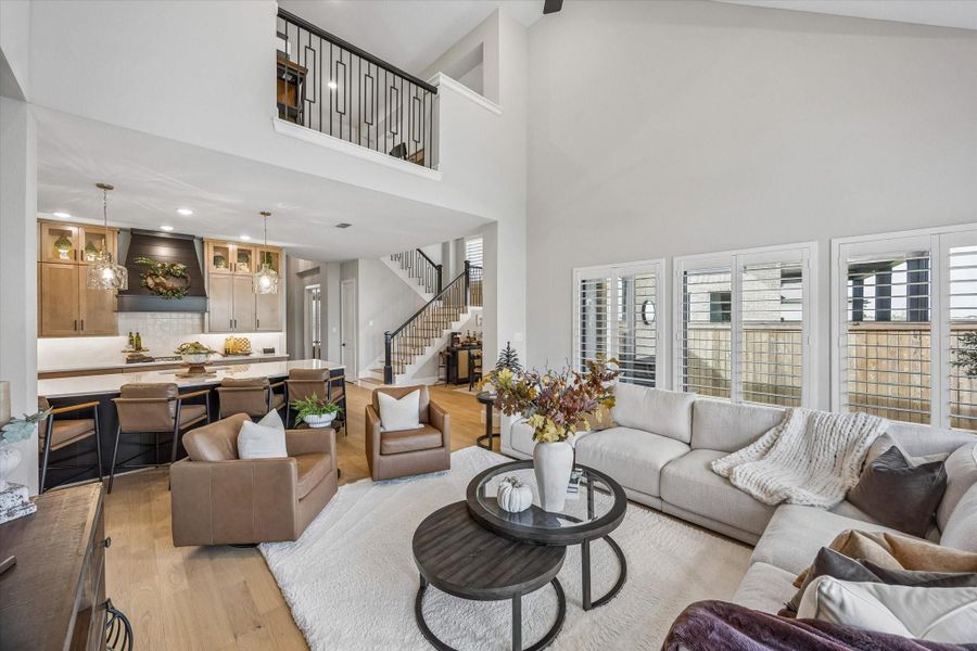 The two story grand living opens to the kitchen, breakfast area and upstairs game room loft.