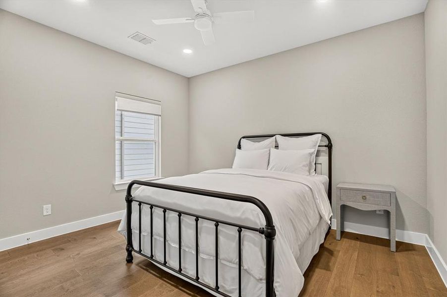 Bedroom featuring wood-finish flooring, recessed lighting, and a ceiling fan Bedroom featuring wood-finish flooring, recessed lighting, and a ceiling fan