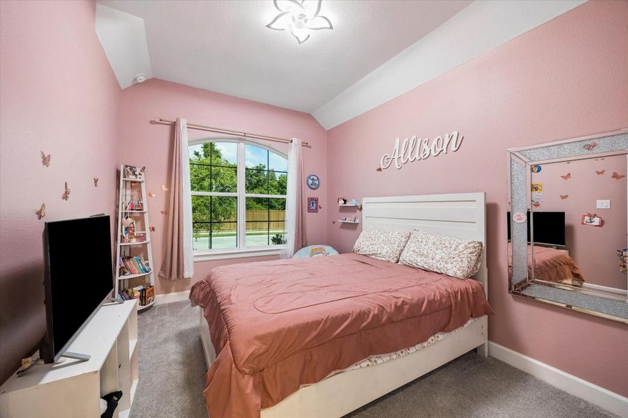 Spacious secondary bedroom with stylish accent wall, plush carpeting, and large windows offering abundant natural light and comfortable accommodations. Spacious secondary bedroom with stylish accent wall, plush carpeting, and large windows offering abundant natural light and comfortable accommodations.