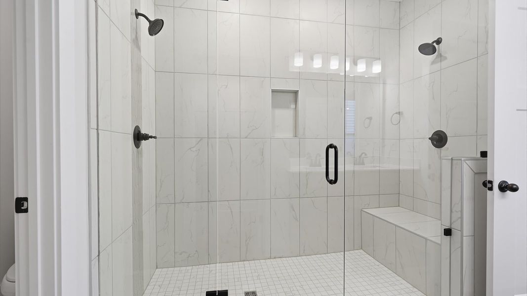 Accomplished design shines in this primary bath with dual vanity and a sleek walk-in shower at Fox Hollow