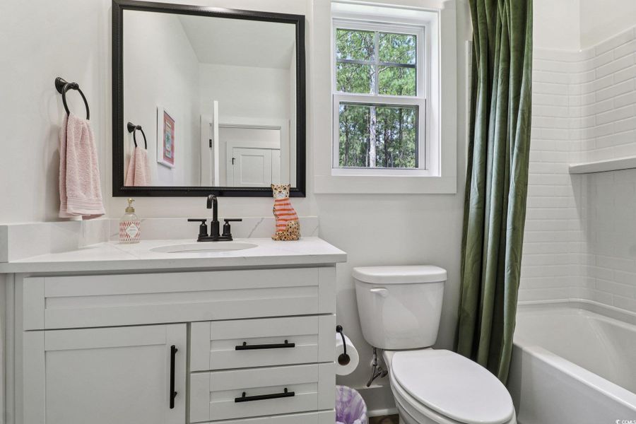 Full bathroom featuring shower / bath combination with curtain and vanity