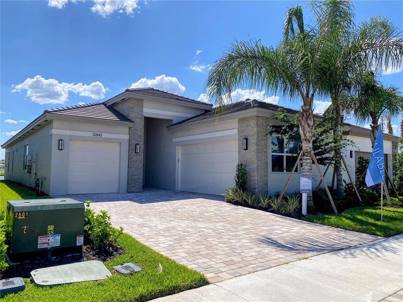 Front exterior of a new home in Valencia Ridge (55+), Wesley Chapel, FL, highlighting curb appeal (Image 2).