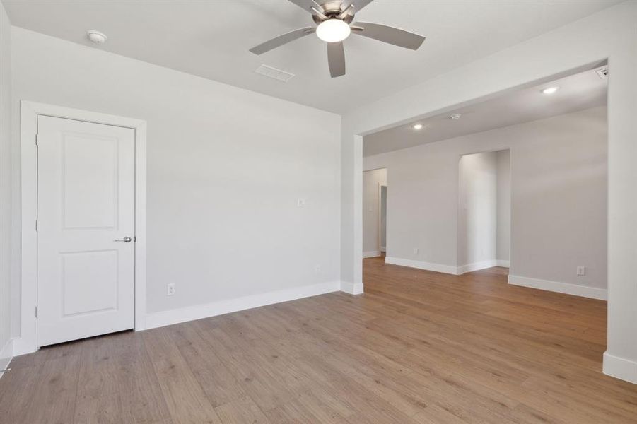 Unfurnished room featuring light wood-type flooring and ceiling fan