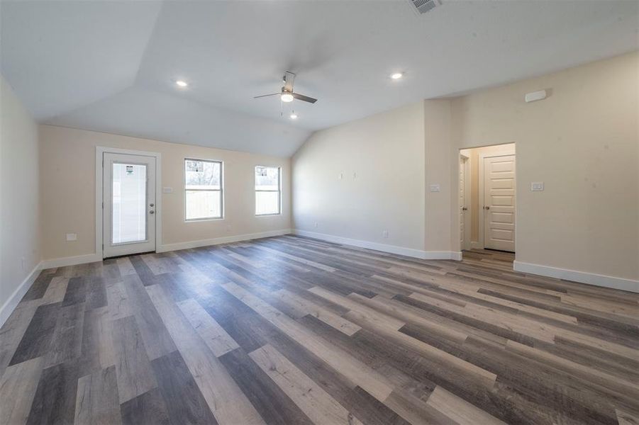 Unfurnished living room with baseboards, ceiling fan, wood finished floors, vaulted ceiling, and recessed lighting