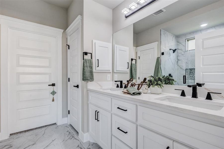 Full bath featuring custom flooring, oversized shower, and double vanity,