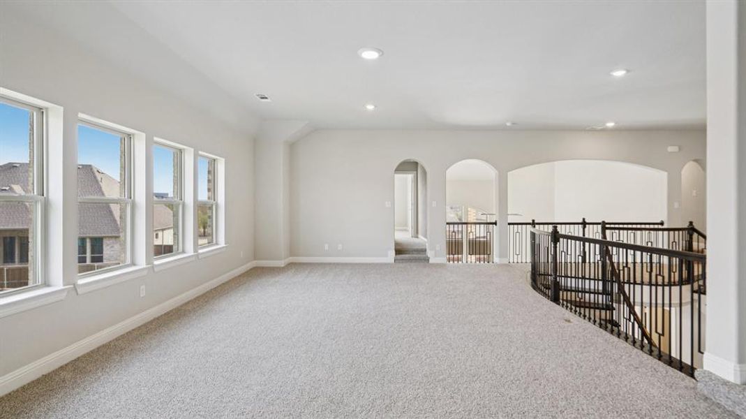 Empty room with carpet floors, recessed lighting, and arched walkways Empty room with carpet floors, recessed lighting, and arched walkways