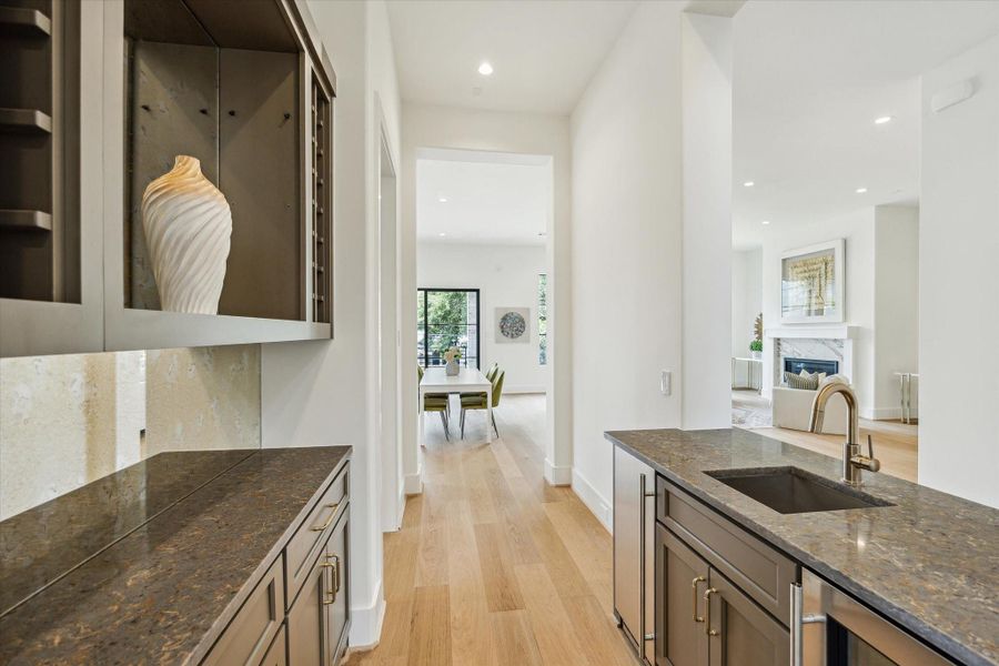 Centrally located entertaining bar  -  features built-in wine rack, wine/beverage cooler, cabinets and quartz countertops.