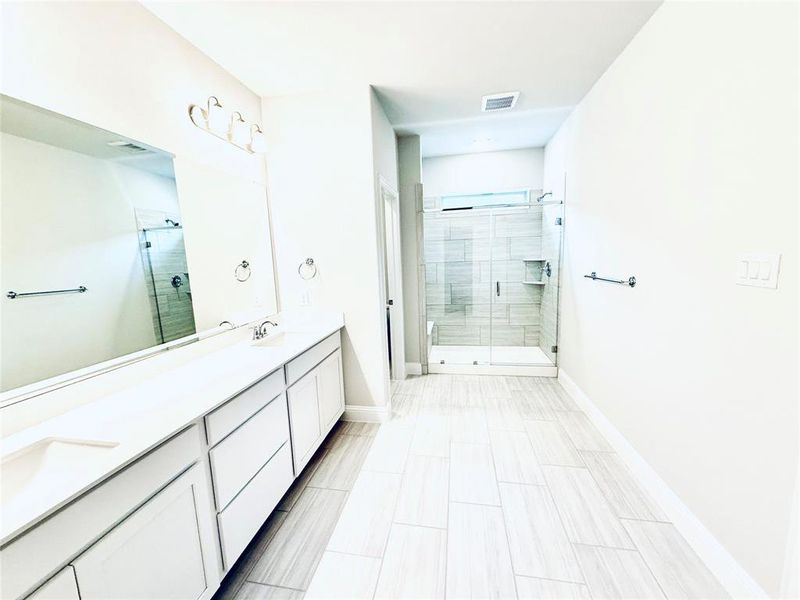 Spacious bathroom featuring a dual vanity with white cabinetry and light-toned countertops