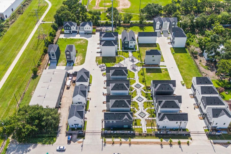 From above, Springwood Villas reveals its harmonious blend of architecture, greenery, and shared spaces. Homes are arranged in elegant rows, connected by winding pathways that lead to a central community courtyard—a lush oasis featuring pergolas, shaded seating, and water fountains.