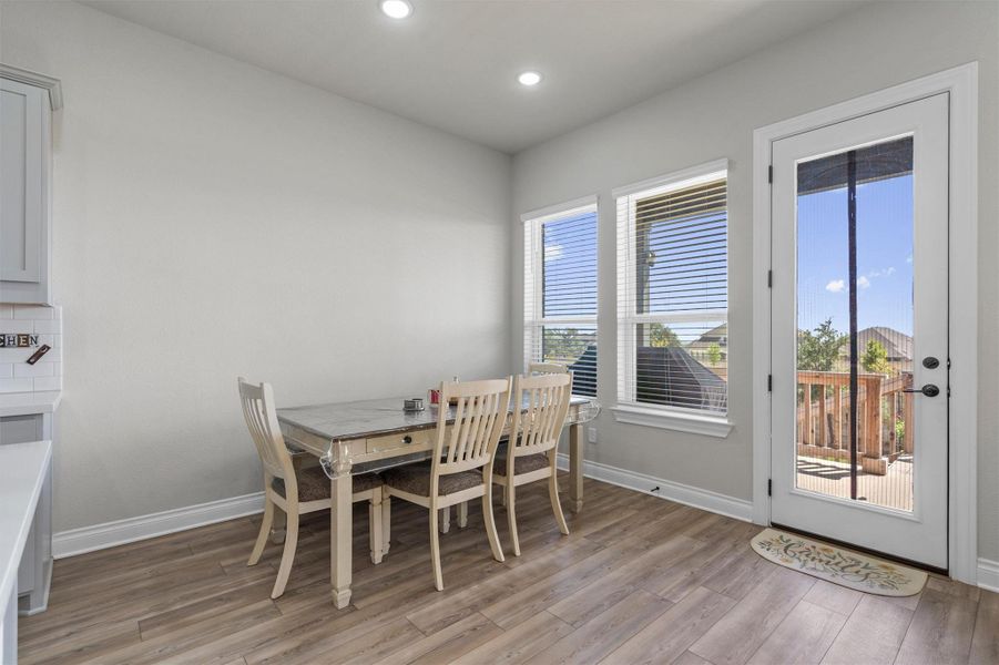 Warm wood flooring, smooth walls, and natural light coming from glass patio doors.