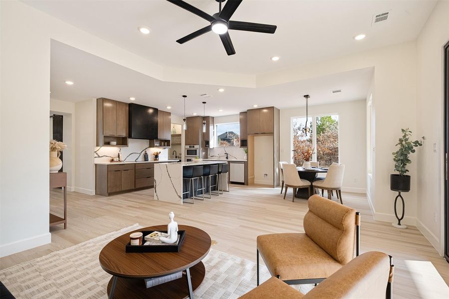 Living room with ceiling fan, light wood-style flooring, and recessed lighting