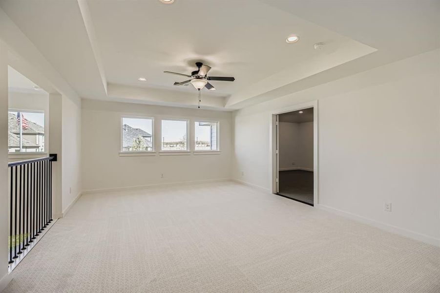 Unfurnished bedroom featuring a tray ceiling, recessed lighting, light carpet, and a ceiling fan Unfurnished bedroom featuring a tray ceiling, recessed lighting, light carpet, and a ceiling fan