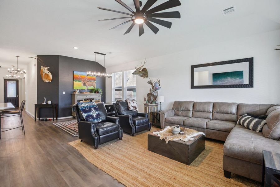 Living room with a chandelier, wood finished floors, recessed lighting, and ceiling fan Living room with a chandelier, wood finished floors, recessed lighting, and ceiling fan