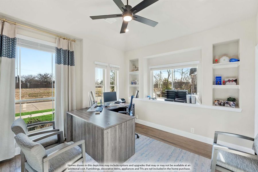 Home office with L-shaped desk, built-in shelves, ceiling fan, and large windows with natural light Home office with L-shaped desk, built-in shelves, ceiling fan, and large windows with natural light