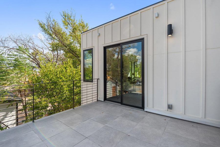 View of exterior entry featuring board and batten siding and a patio