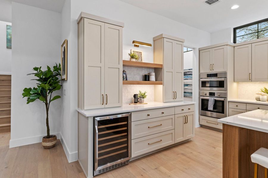 Bar featuring wine cooler, recessed lighting, stainless steel double oven, light wood-style flooring, and tasteful backsplash