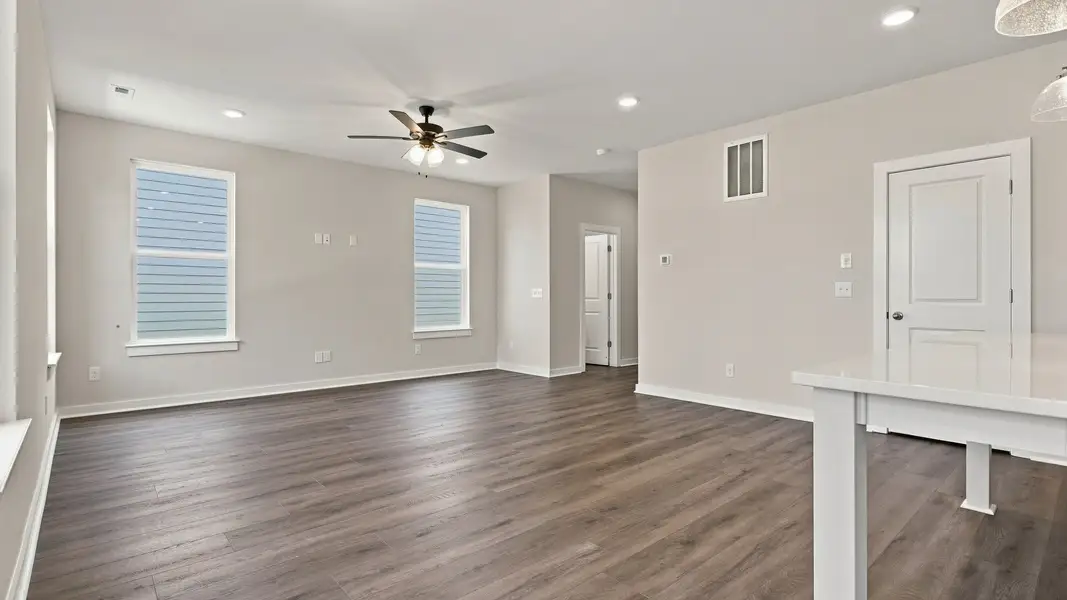 View from kitchen of living space filled with natural lighting from various windows