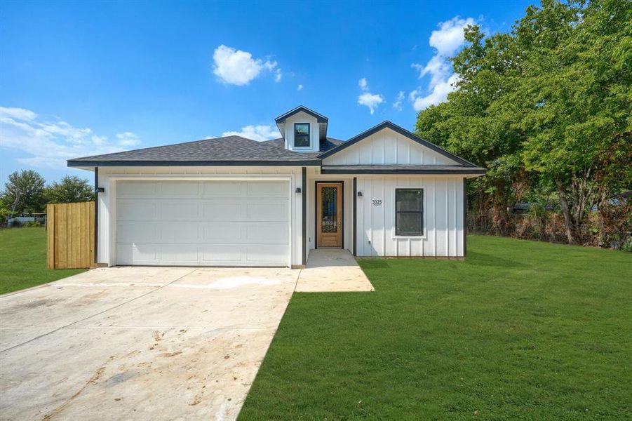 View of front of house featuring a garage and a front yard