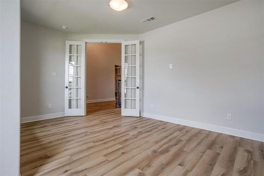 Empty room featuring french doors and light hardwood / wood-style floors