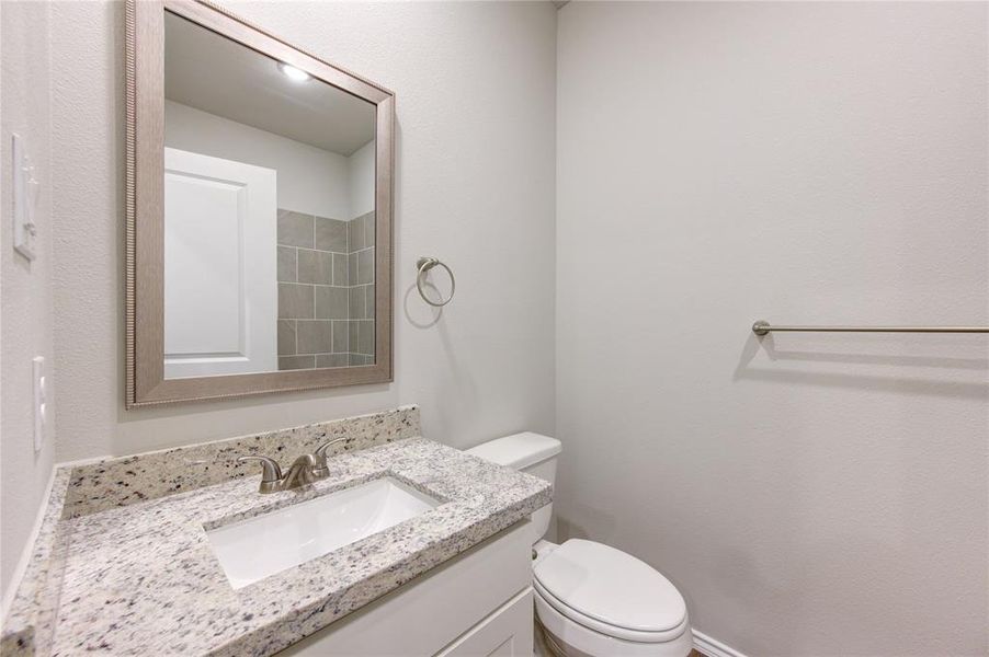 Bath 2 features a stylish framed mirror, granite counters, ceramic tile bath tub walls.