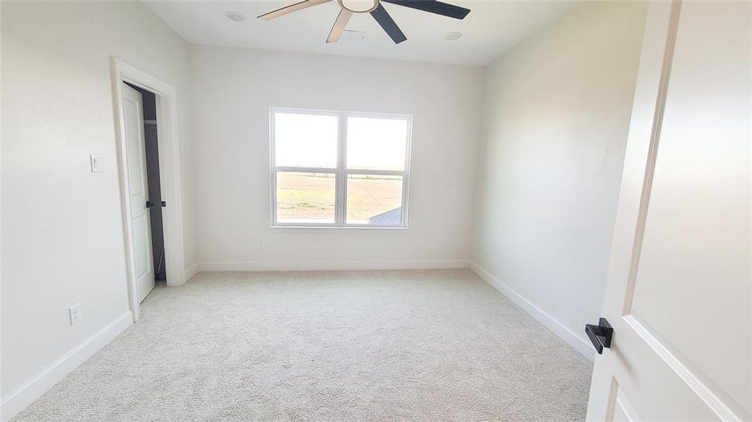 Empty room with light carpet and ceiling fan