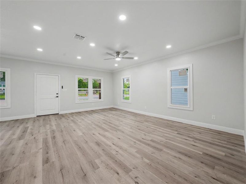 Spacious interior featuring wood-finish flooring, recessed lighting, and a ceiling fan