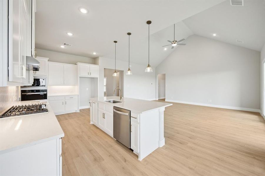 Kitchen featuring white cabinetry, an island with sink, tasteful backsplash, decorative light fixtures, and recessed lighting