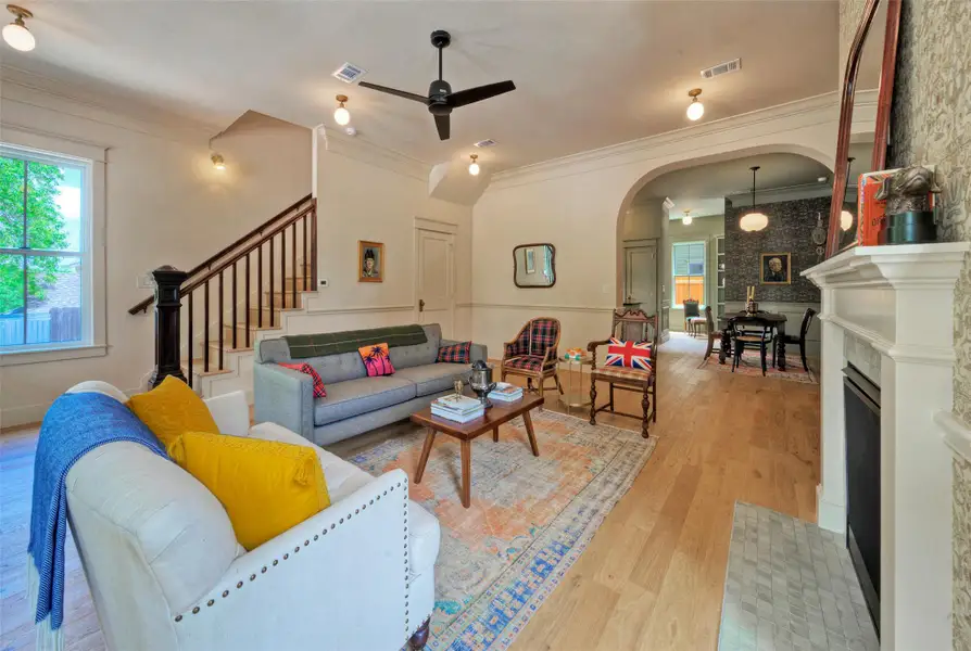 Hardwood floors flow through this inviting living area, featuring a cozy fireplace, beautiful crown molding and chair rail and a prominent staircase.