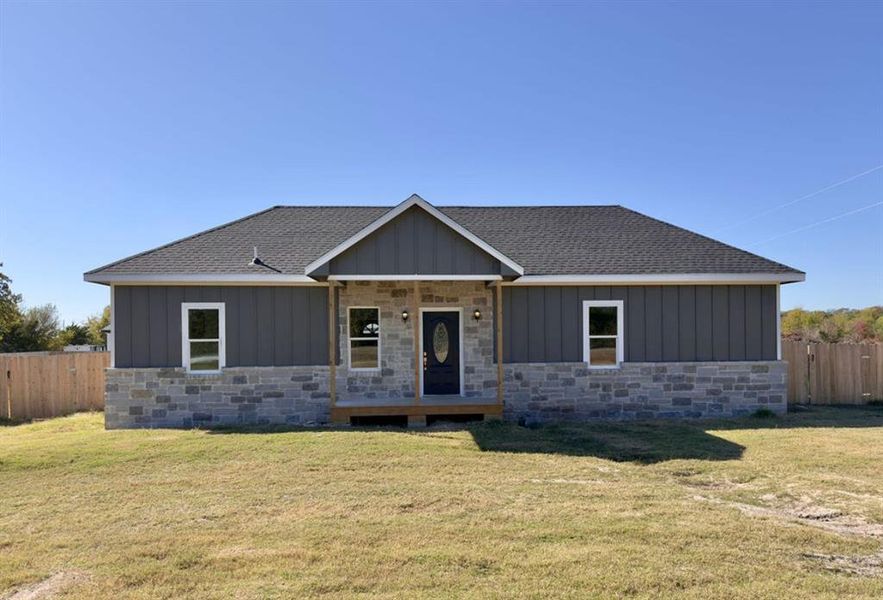 View of front of property with board and batten siding, a porch, a shingled roof, and stone siding View of front of property with board and batten siding, a porch, a shingled roof, and stone siding