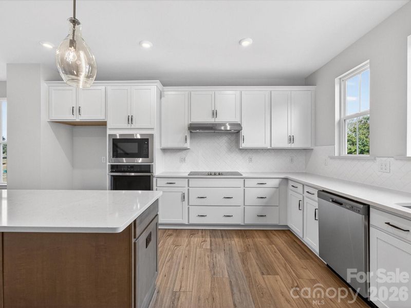 Gourmet Kitchen with Modern Backsplash and Crisp White Cabinetry.