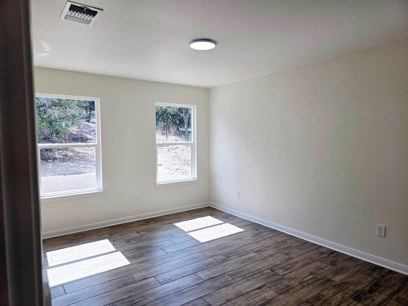 Spare room with baseboards and dark wood-style floors