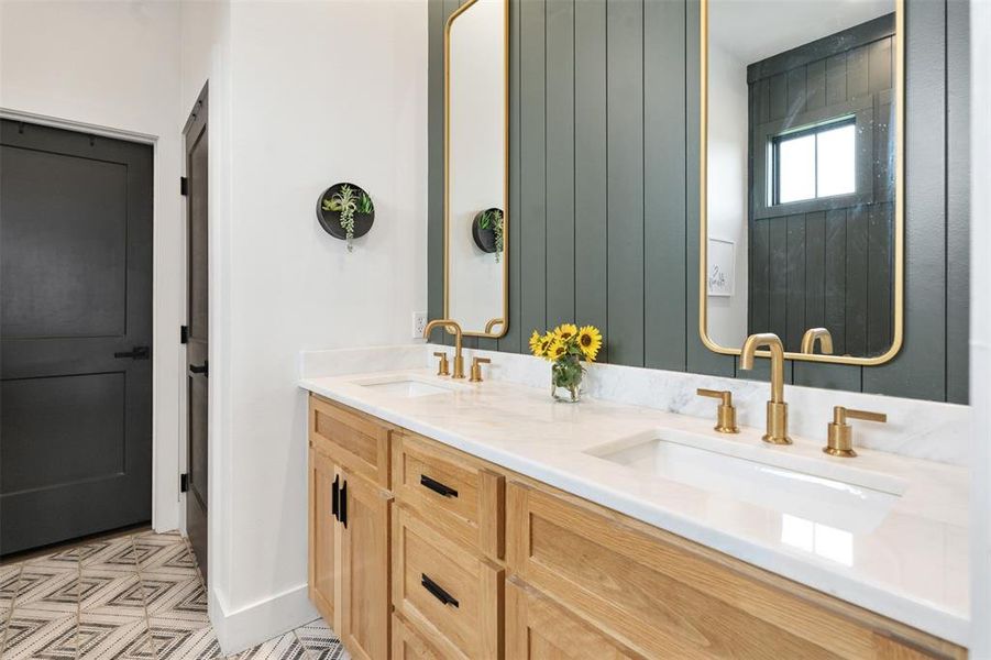 Full bath featuring double vanity and baseboards