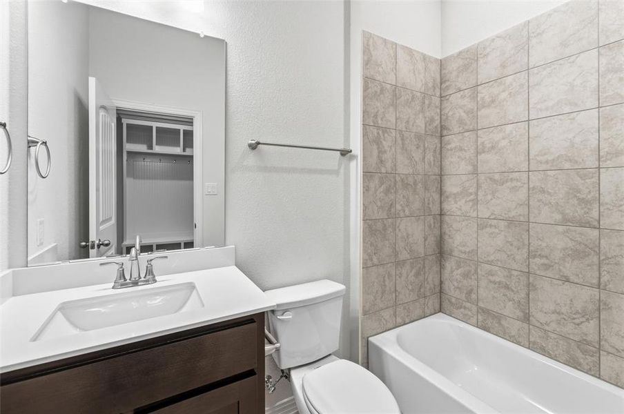 Bathroom with vanity, a textured wall, and  shower combination
