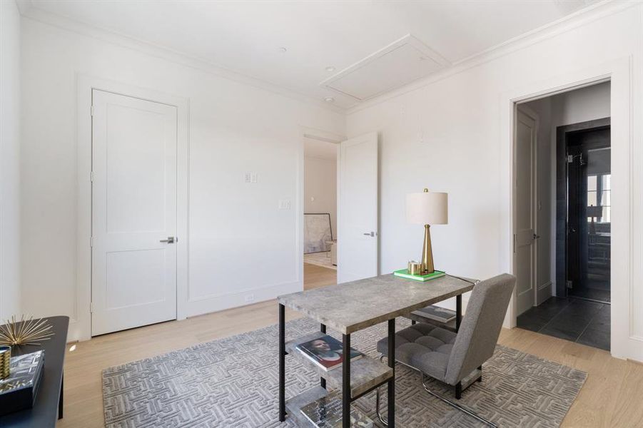 Also sharing the fourth floor, the third bedroom will feature hardwood floors, statement light, oversize windows with unbeatable views, a built out walk-in closet, and luxe ensuite bath. (Shown here as additional workspace). (photo of interior model home with smaller floor plan)