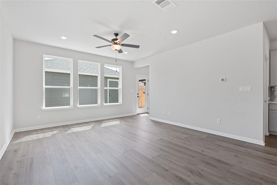Spare room with a ceiling fan, wood finished floors, and recessed lighting