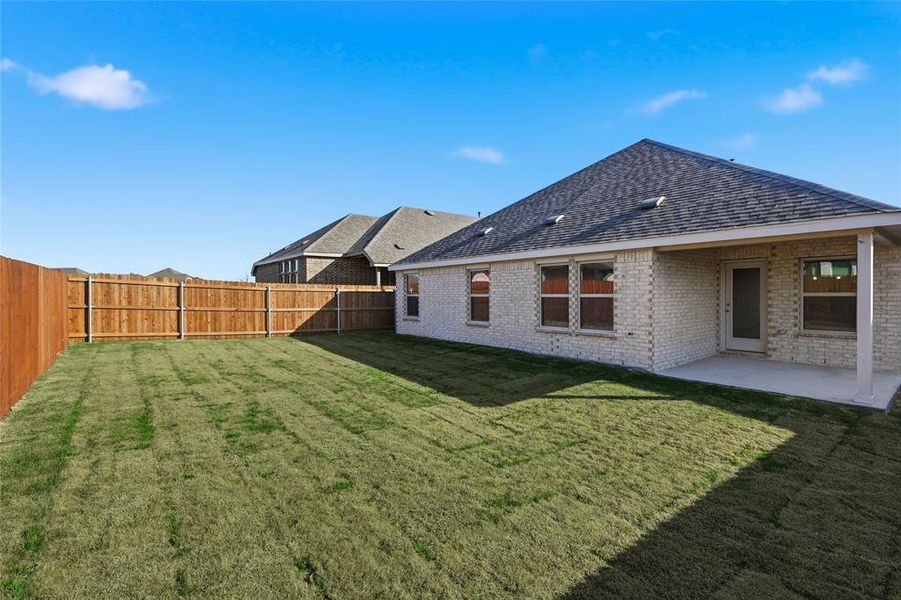 Back of property featuring brick siding, a fenced backyard, a patio area, and roof with shingles Back of property featuring brick siding, a fenced backyard, a patio area, and roof with shingles