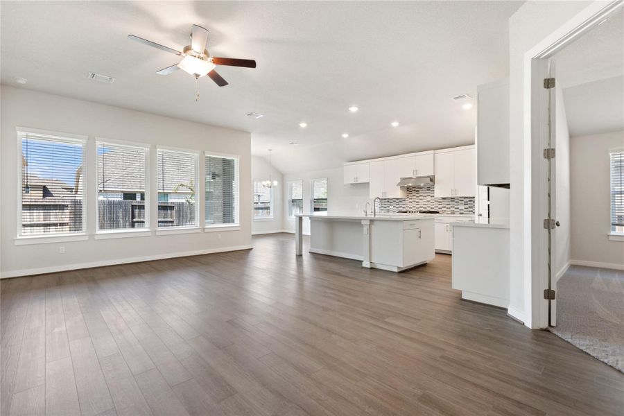 Living area featuring dark wood-type flooring, recessed lighting, a ceiling fan, and lofted ceiling