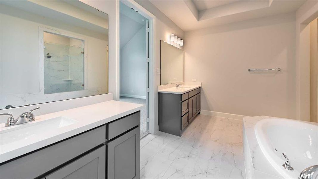 Bathroom with tile patterned flooring, independent shower and bath, a raised ceiling, and double vanity