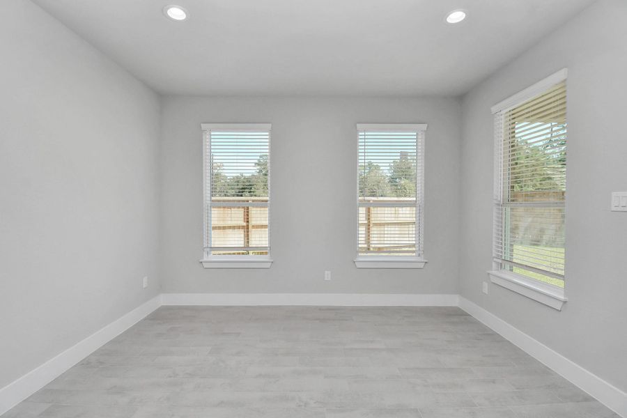 Create lasting memories with your family and friends at the dining table! This expansive dining room showcases sophisticated flooring, custom paint, and seamlessly connects to the family room and kitchen, providing an open and inviting atmosphere. Sample photo of completed home with similar floor plan. Actual colors and selections may vary.