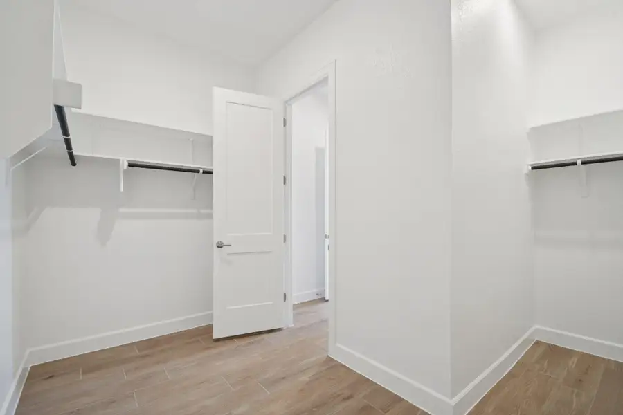 Walk in closet with light wood-type flooring