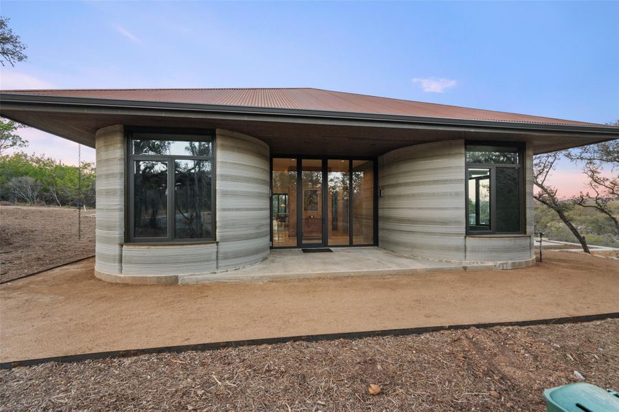 View of exterior entry featuring a patio area and a metal roof - not fully landscaped
