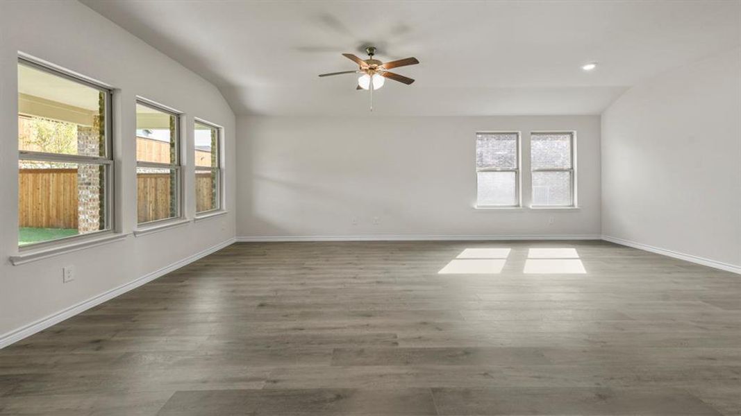 Spacious interior with wood-finish flooring, vaulted ceilings, and white walls