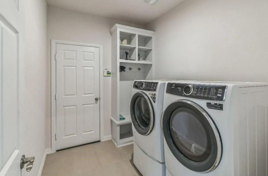 Washroom featuring washer and clothes dryer and light tile patterned floors