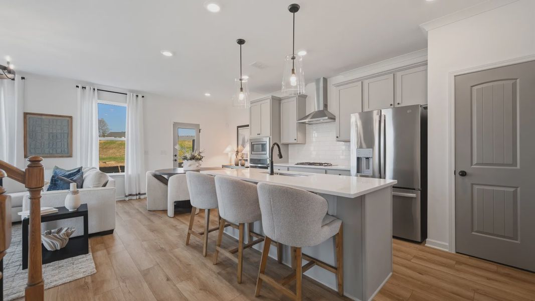 Bright open kitchen with quartz island and modern finishes in Langley Overlook townhome in Loganville, GA.