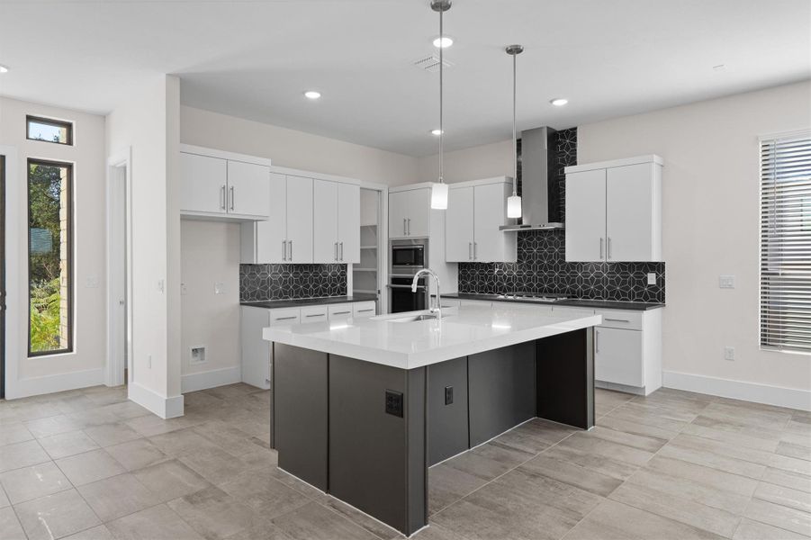 Kitchen featuring plenty of natural light, pendant lighting, white cabinetry, backsplash, and recessed lighting Kitchen featuring plenty of natural light, pendant lighting, white cabinetry, backsplash, and recessed lighting