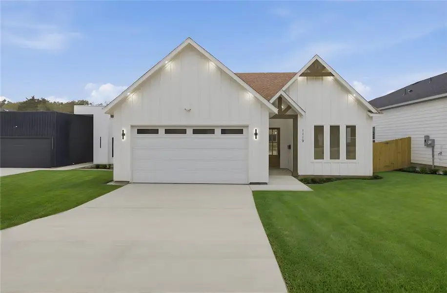 Modern farmhouse style home featuring board and batten siding, driveway, and a garage