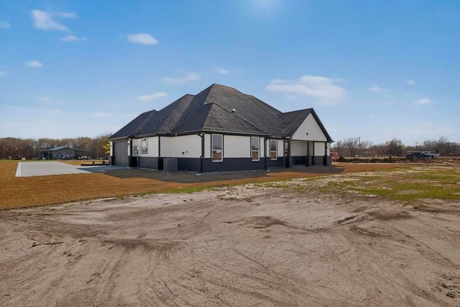 View of side of home featuring driveway and roof with shingles View of side of home featuring driveway and roof with shingles