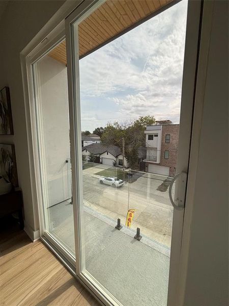 Doorway to outside featuring wood finished floors and baseboards Doorway to outside featuring wood finished floors and baseboards