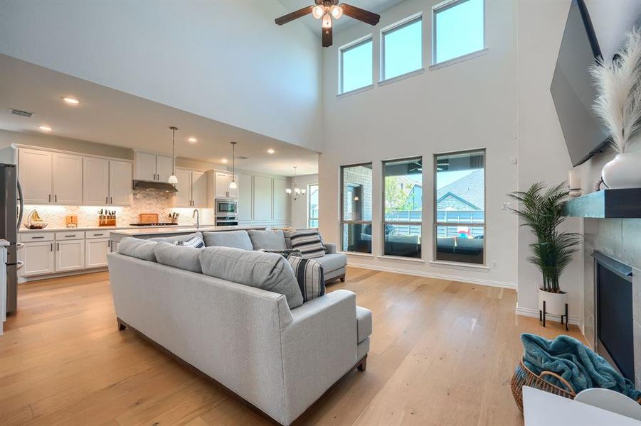 Spacious living room featuring plenty of natural light, ceiling fan, light hardwood / wood-style floors, and a fireplace