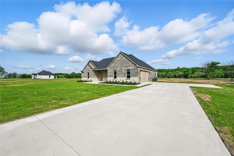 French country style house featuring concrete driveway, a garage, brick siding, and a front lawn French country style house featuring concrete driveway, a garage, brick siding, and a front lawn